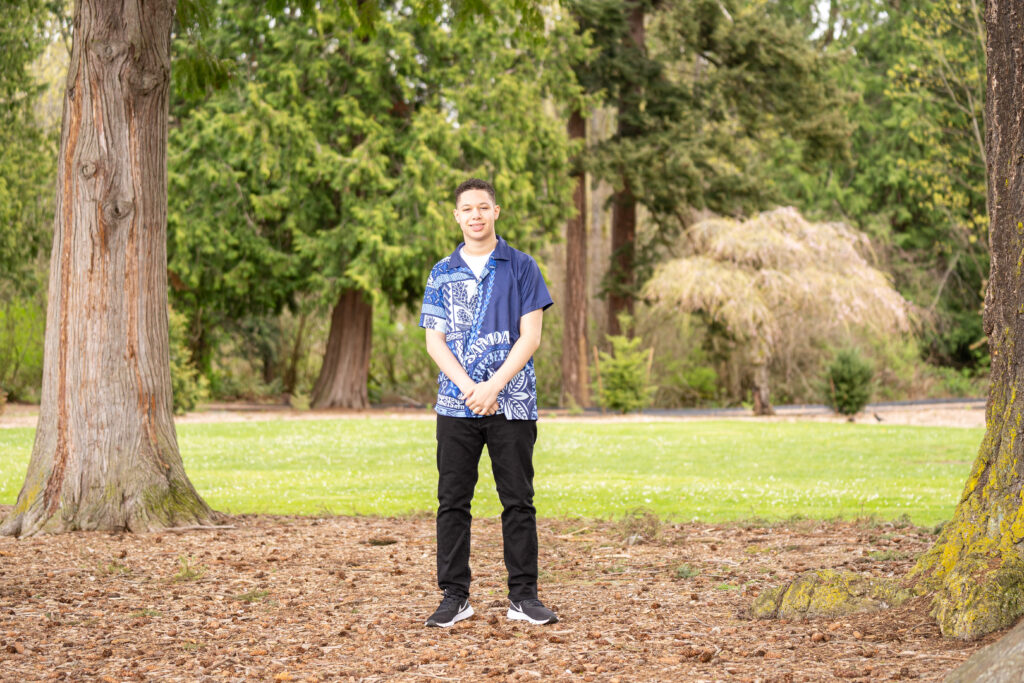 Trenton, a senior, standing in his Hawaiian t-shirt at Harborview Park in Everett during his senior photo session.