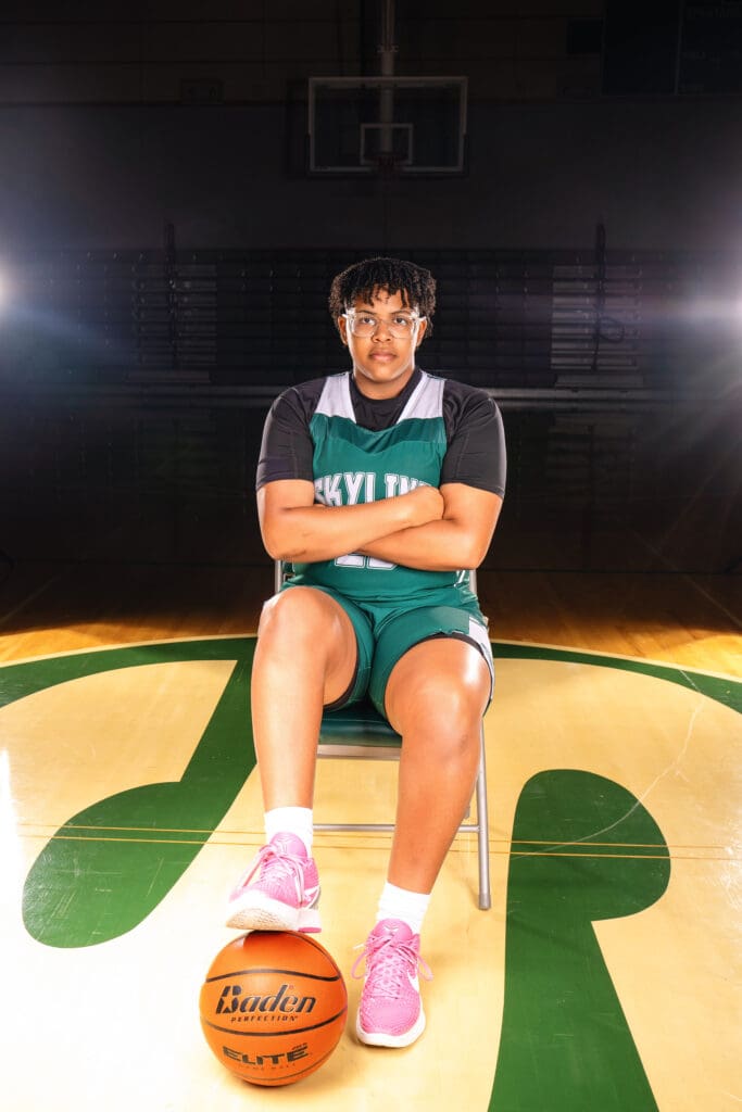 Senior athlete posing on the basketball court at Skyline High School in Sammamish.