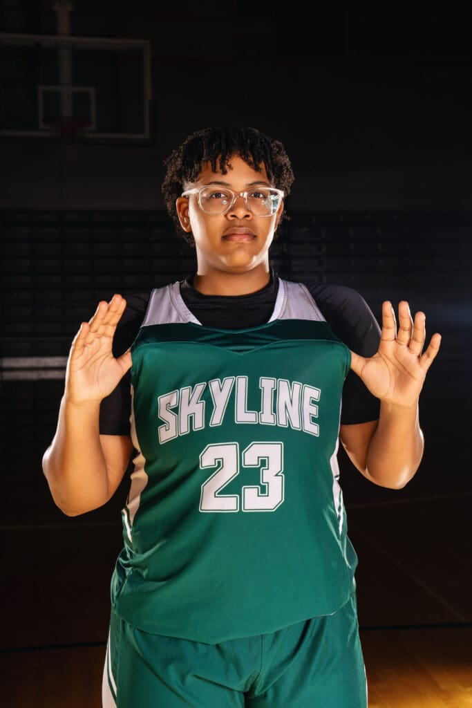 Skyline High School senior celebrates basketball journey in a gym photography session.